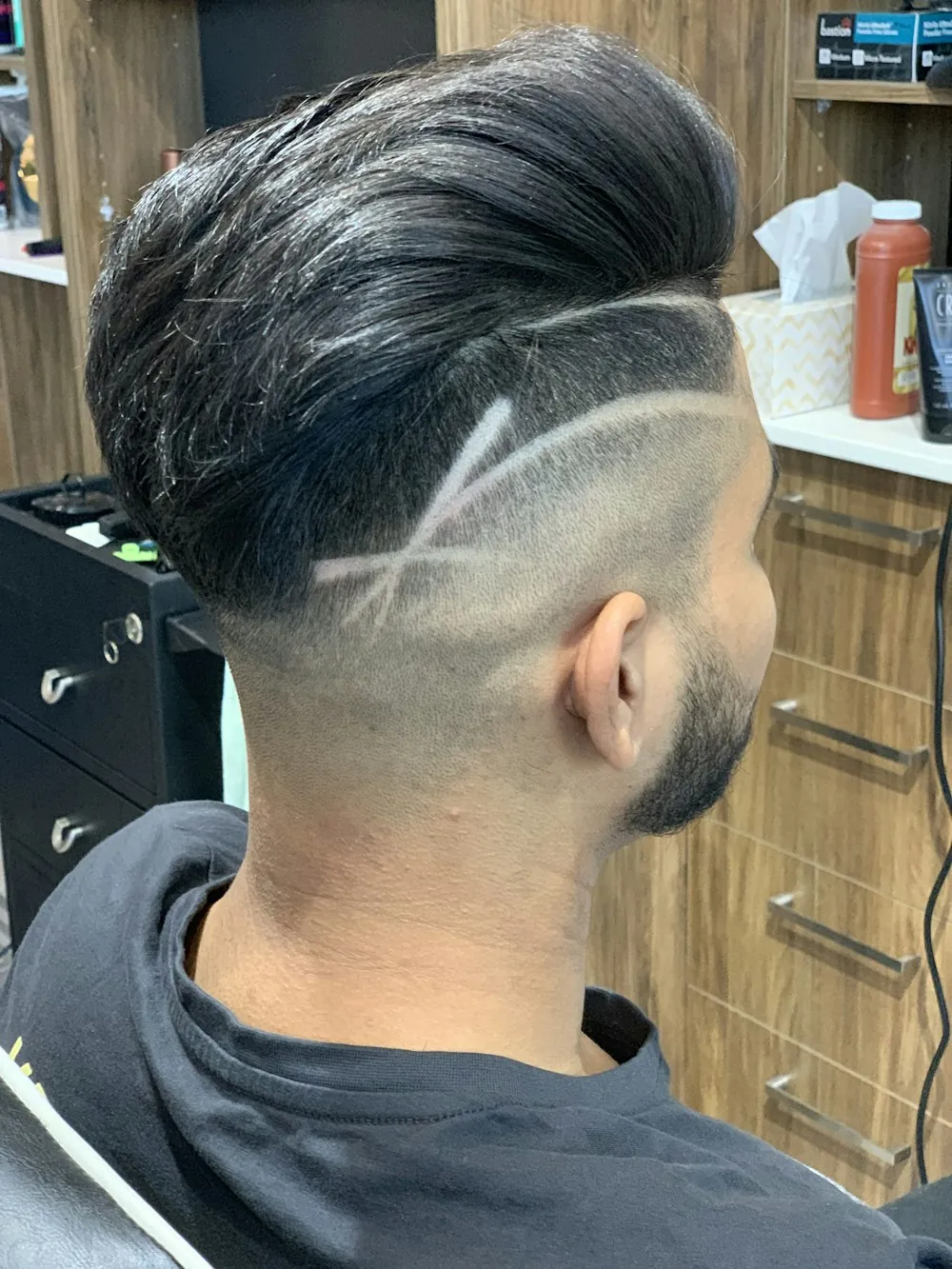 A skin fade with a line shaved into the side, seen from behind
