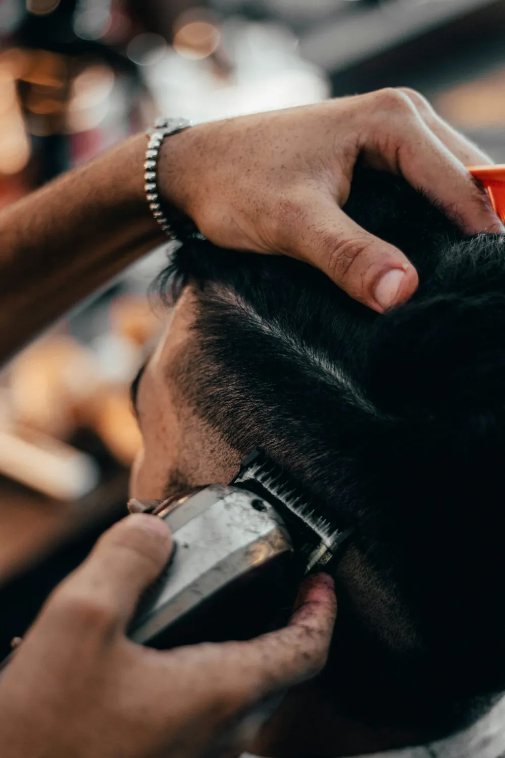 Close up of clippers taking a fade up the side of a client's head