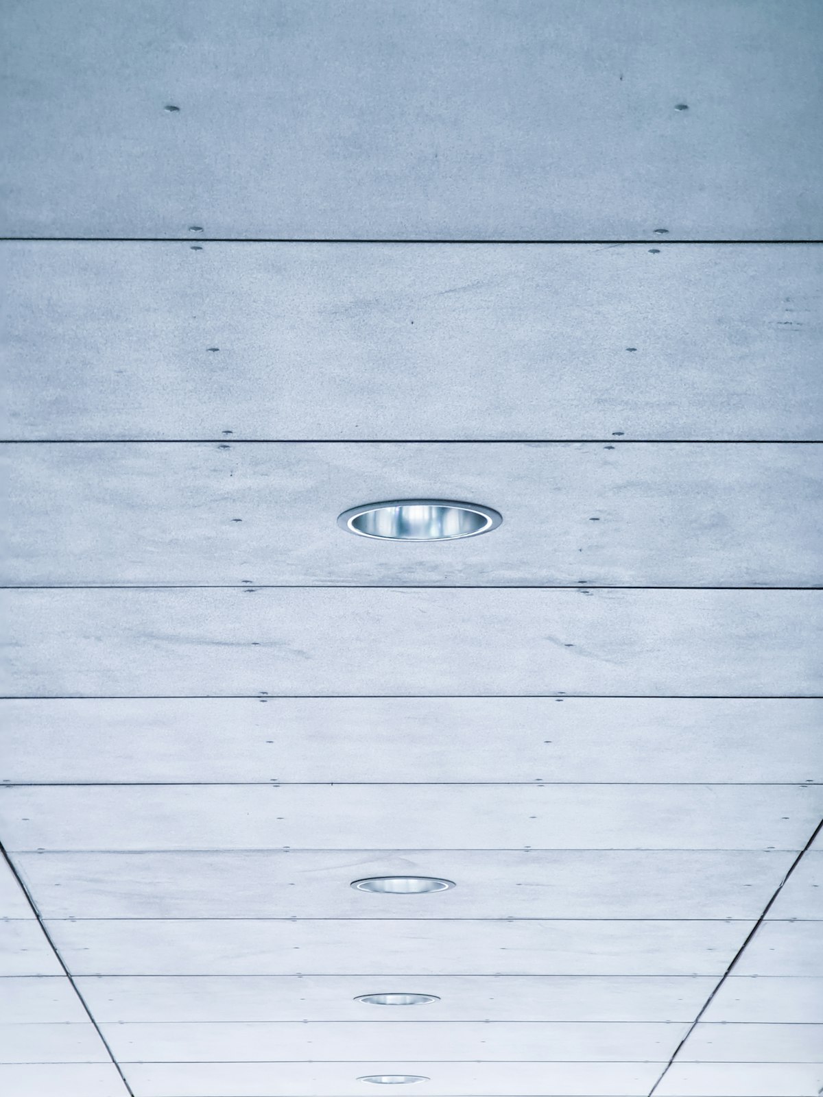 Painted plank ceiling with a row of recessed lights