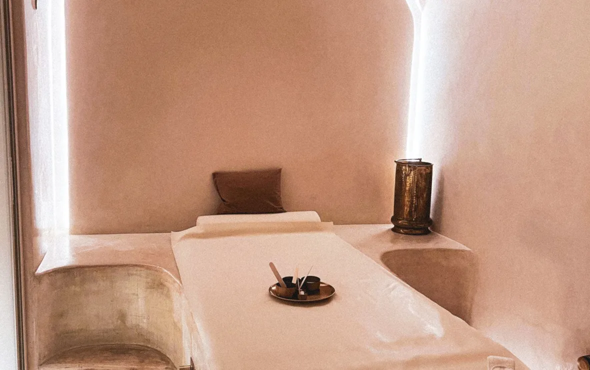 A warm treatment room with an arched ceiling and a made up treatment bed