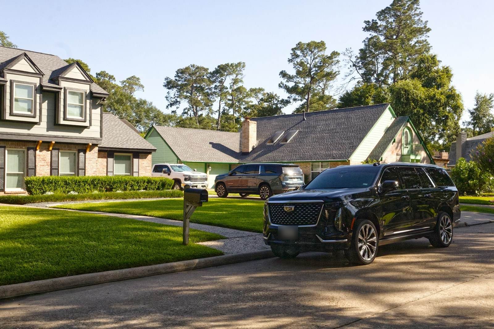 Black SUV with tinted windows parked on a sunny residential street