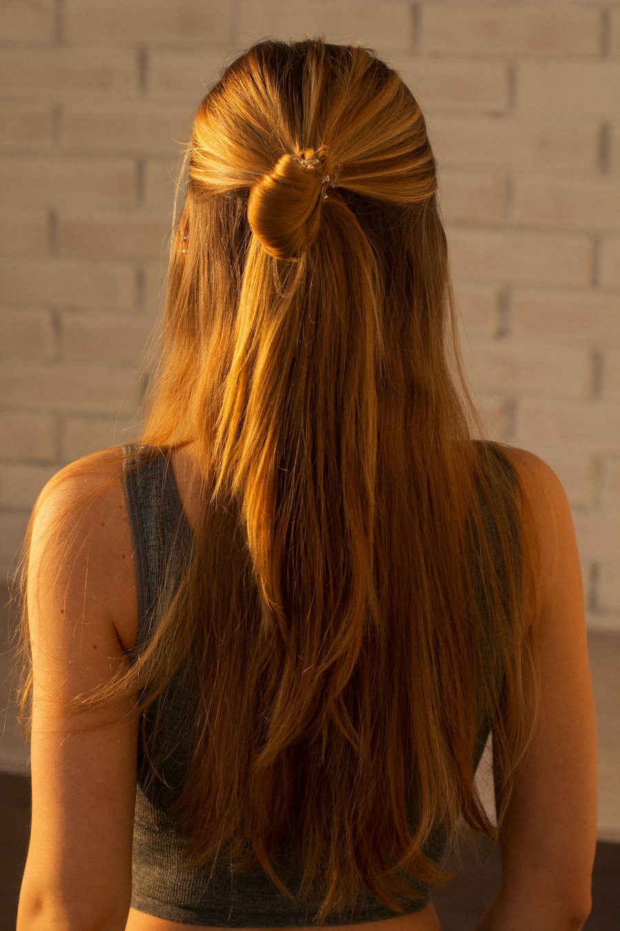 Long straight copper hair with a knotted half-up section, seen from behind
