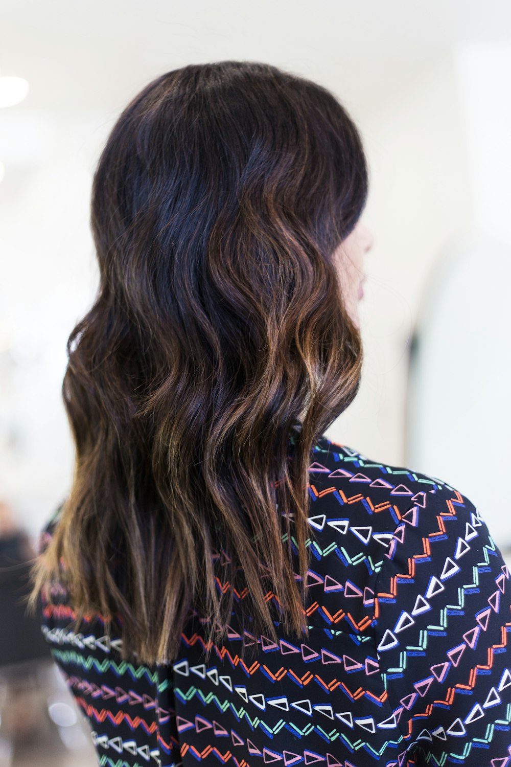 Dark brown hair in loose waves, seen from behind